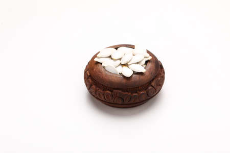 Heap of pumpkin seeds in bowl on white backgroundの写真素材
