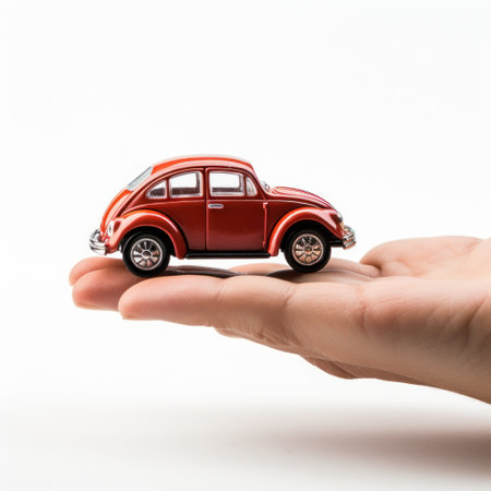 Car toy on palm over white backgroundの素材