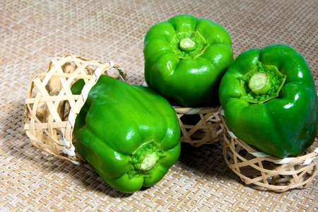 Green pepper went into a small bamboo basketの写真素材