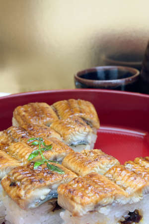 This sushi is made by pressing the rice and eel in the wooden frame.の写真素材