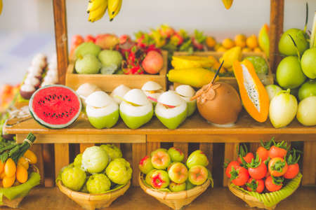 close up Miniature clay figurine Thailand's floating market,Miniature boat carrying tropical fruit on wood backgroundの写真素材