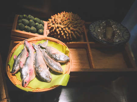 close up Miniature clay figurine Thailand's floating market,Miniature boat carrying tropical fruit on wood backgroundの写真素材