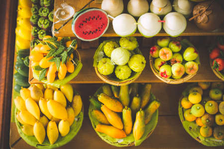 close up Miniature clay figurine Thailand's floating market,Miniature boat carrying tropical fruit on wood backgroundの写真素材