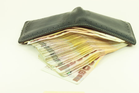 black leather wallet with money isolated on white backgroundの写真素材