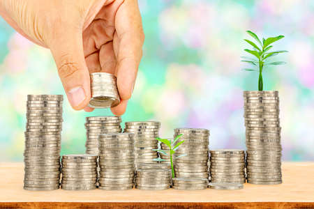 Saving money concept,Male hand putting money coin stack growing businessの写真素材