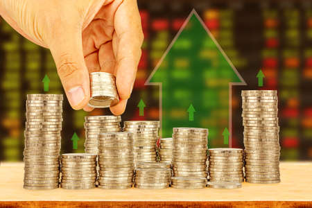 Saving money concept,Male hand putting money coin stack growing businessの写真素材