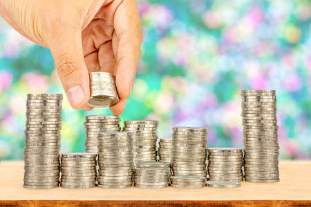Saving money concept,Male hand putting money coin stack growing businessの写真素材