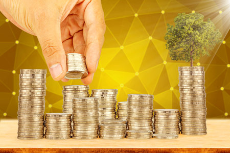 Saving money concept,Male hand putting money coin stack growing businessの写真素材