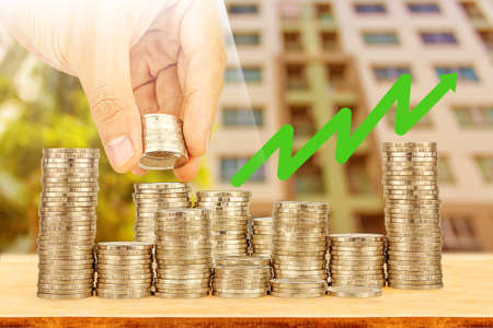 Saving money concept,Male hand putting money coin stack growing businessの写真素材