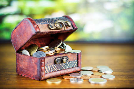 Saving money concept preset putting money coin stack growing business on bright light glowing bokeh background, business finance wealth and success concept.の写真素材