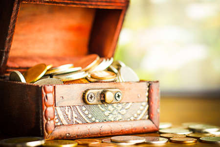 Saving money concept preset putting money coin stack growing business on bright light glowing bokeh background, business finance wealth and success concept.の写真素材
