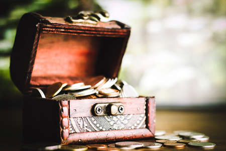 Saving money concept preset putting money coin stack growing business on bright light glowing bokeh background, business finance wealth and success concept.の写真素材