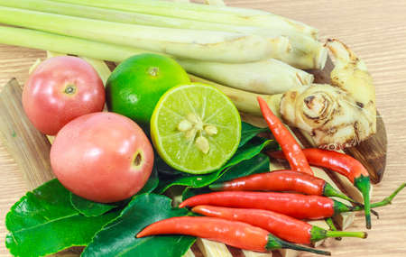 kaffir lime leaf, lemon, lemongrass, galangal, chili, herb and spicy ingredients for making Thai food on wood background.の写真素材
