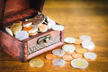 Saving money concept preset putting money coin stack growing business on bright light glowing bokeh background, business finance wealth and success concept.の写真素材
