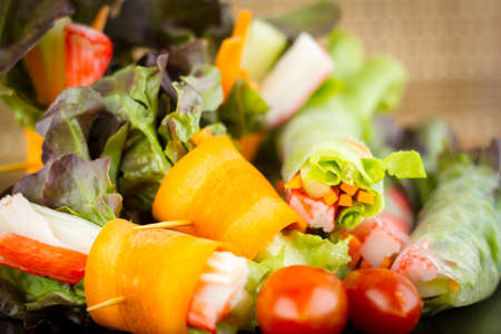 Close up of fresh salad of lettuce, cucumber and tomato on plate for healthy eating.Fresh vegetable salad in Black plate  on wood table. Salad for healthy. Fresh raw vegetables salad background.の写真素材