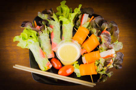 Close up of fresh salad of lettuce, cucumber and tomato on plate for healthy eating.Fresh vegetable salad in Black plate  on wood table. Salad for healthy. Fresh raw vegetables salad background.の写真素材