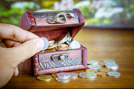 Saving money concept preset putting money coin stack growing business on bright light glowing bokeh background, business finance wealth and success concept.の写真素材