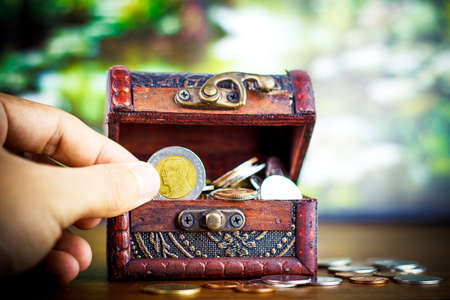Saving money concept preset putting money coin stack growing business on bright light glowing bokeh background, business finance wealth and success concept.の写真素材