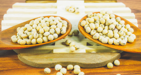 Soy bean in wood spoon full on wooden background,Macro shot of soybeans fills the frame, selective...