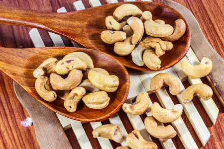 Cashew nuts on a wooden spoon.の写真素材