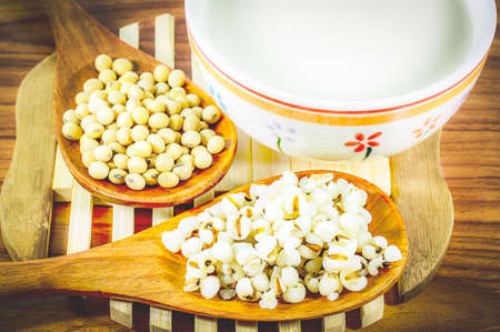 Soy milk on wooden background with soybeans or soya beans placed on side, selective focus,Healthy foodの写真素材