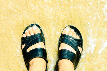 Vacation on ocean beach,Foot on sea sand, relaxing on beach enjoying sun on sunny summer day.