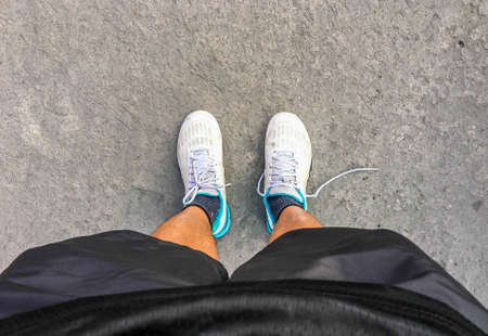 Teenage legs in  sneakers shoes sport standing walking on paving, top view. sport conceptの写真素材