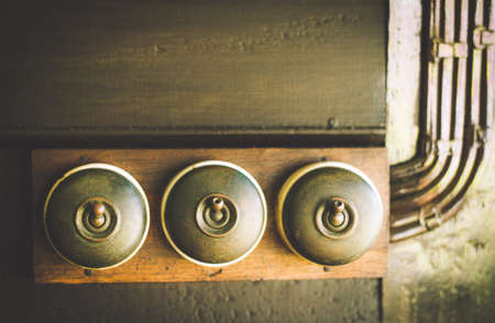 Close up of detail of a very old light switch on old wood texture backgroundsの写真素材