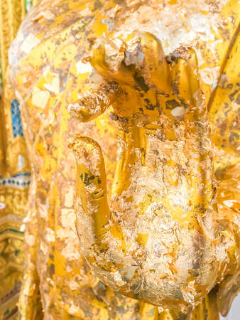Close up hand filled with gold leaf of statue Buddha. concept shows the devotion of the Buddhists.の写真素材