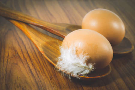 Top view of Eggs lay on wood spoon on wooden background. Food ingredient.の写真素材