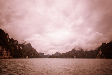 Landscape with mountains trees and mist and a lake  .Evening after heavy rainy day
