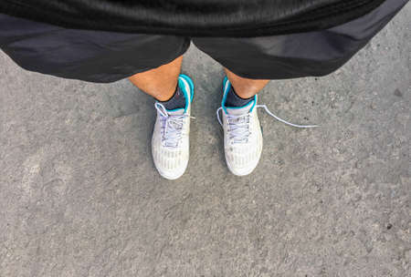 Teenage legs in  sneakers shoes sport standing walking on paving, top view. sport conceptの写真素材