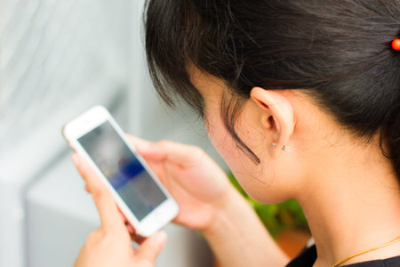 Happy young Asian woman with smartphone,Young female is reading information on web page via her...