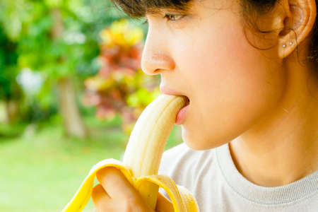 woman eat bananas,Healthy food, bananas rich in vitamins, healthy lifestyle and prevention of vitamin deficiency.の写真素材