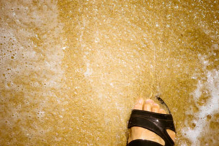 Vacation on ocean beach,Foot on sea sand, relaxing on beach enjoying sun on sunny summer day.の写真素材