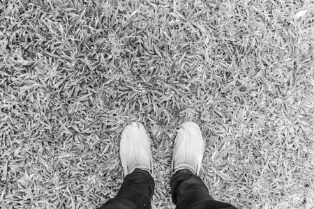 black and white picture Selfie of foot and legs with leather shoes seen from above, vintage process