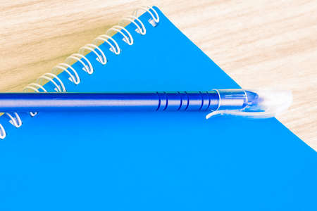 Pen blue and Blank blue book empty cover book spiral stationery school supplies for education business idea book cover design note pad memo on wooden background.の写真素材