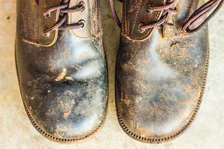 Old black leather shoes on the floor. Pair of old dirty black leather shoes.の写真素材