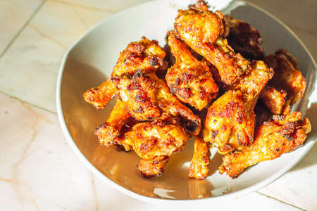 Grilled chicken drumsticks fried crispy marinated with honey is served in a flat white dish on a white background , Asian flavors and style, close-up の写真素材