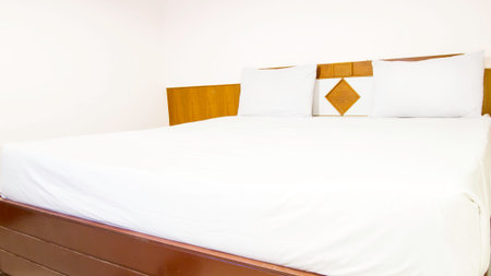 Close up white bedding sheets and pillow on natural wood wall room background