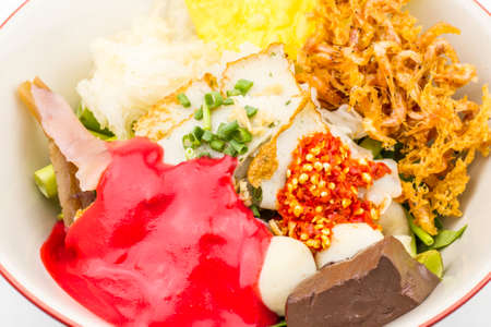 Thai style spicy instant noodles soup in bowl, Yentafo Tom Yum with Thai herbs, Thai food, Noodle soup on white background.の写真素材