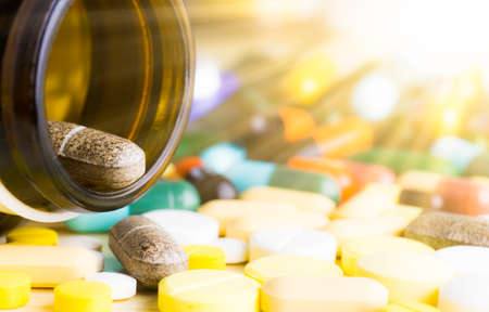 Medicine pills or capsules on wood background. Drug prescription for treatment medication.の写真素材