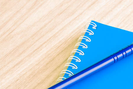 Pen blue and Blank blue book empty cover book spiral stationery school supplies for education business idea book cover design note pad memo on wooden background.の写真素材