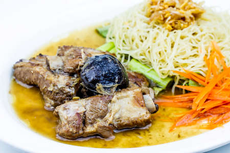 Baked pork ribs with noodle on white plate, Thai style food on white backgroundの写真素材