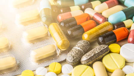 Medicine pills or capsules on wood background. Drug prescription for treatment medication.の写真素材