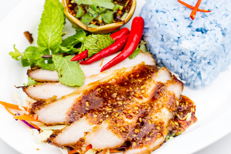tasty slice grilled pork spicy with rice on plate,Thai food, Noodle soup on white background.の写真素材