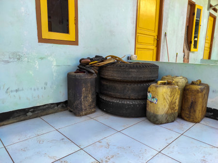 Old rusty cans and old tires on the floor of the old houseの写真素材