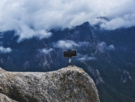 Phone on a tripod on high mountain peak, Seoraksan National Park, South Koreaの写真素材