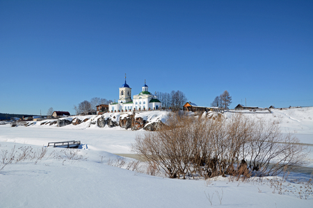 View to Russian Orthodox "St. George" Church was founded in 1806 year on the shore of frozen Chusovaya river in Sloboda village, Sverdlovsk region, Russia in the beginning of Spring.の写真素材