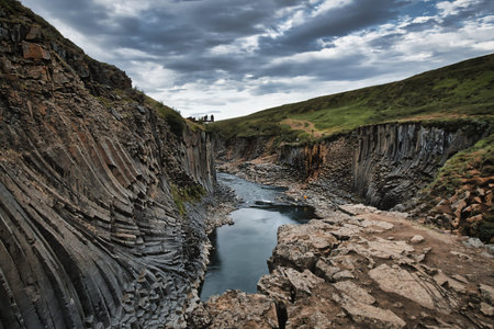 Studlagil Canyon in Iceland, view from the cliff into the canyon, moving clouds in the backgroundの写真素材